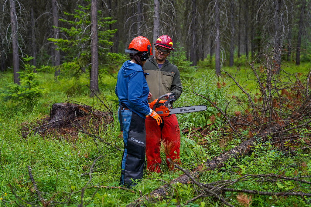 A DNRC forester helps a landowner with a chainsaw