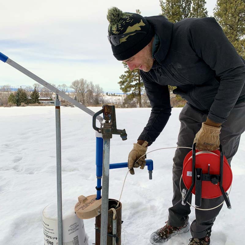 Person measuring water in a well