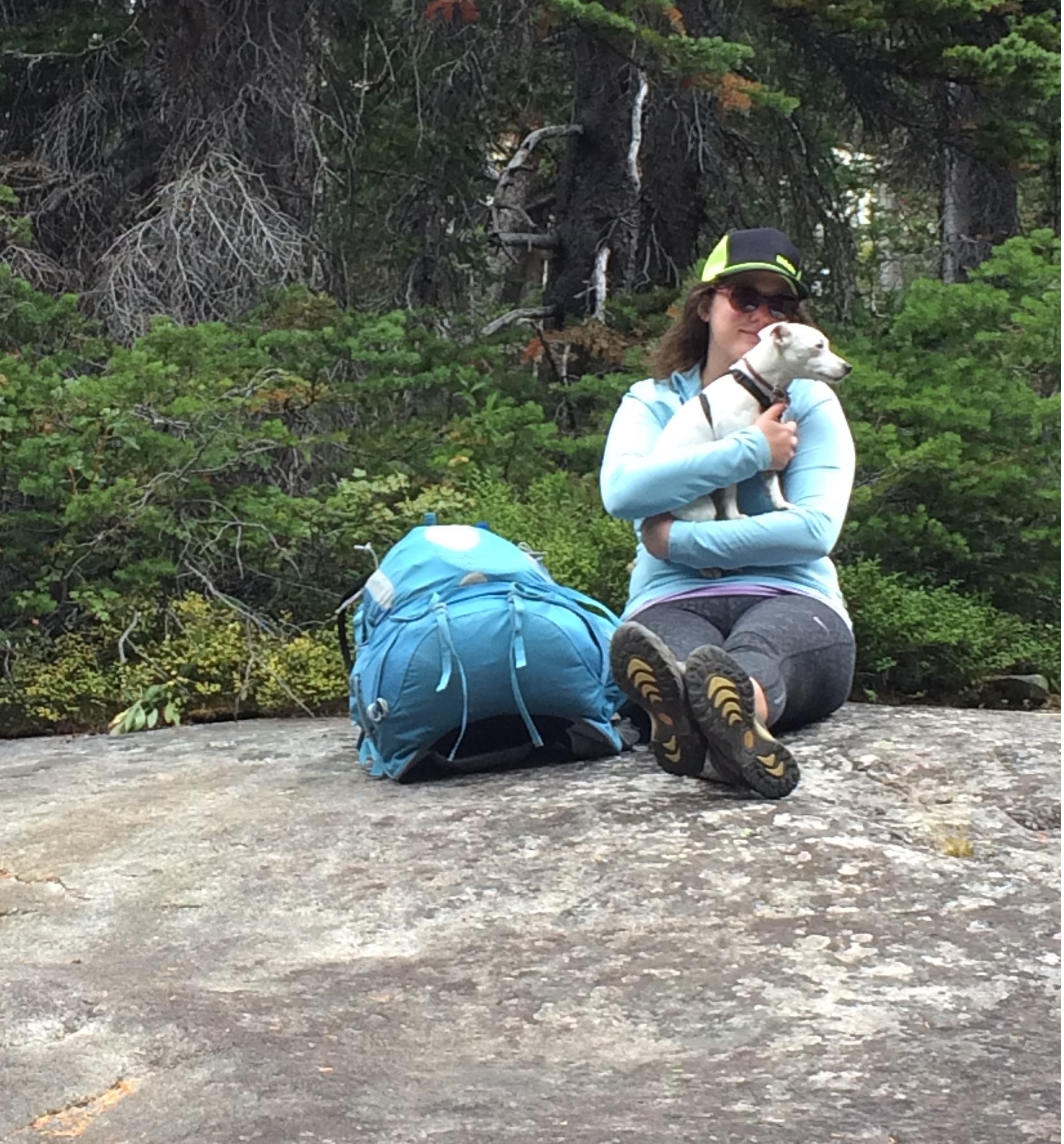 woman with dog on rock