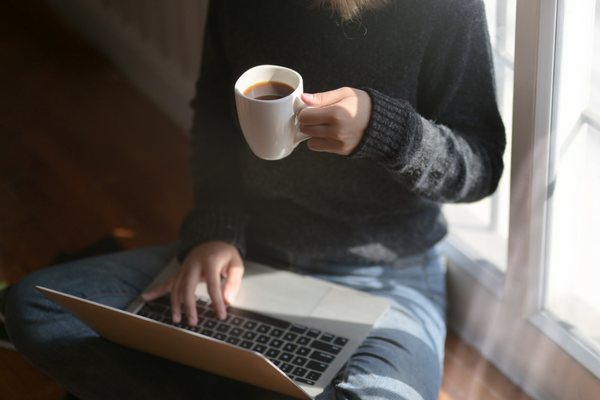 Laptop search with cup of coffee.