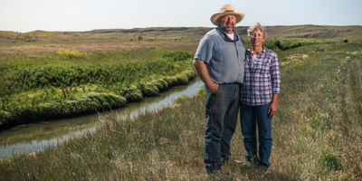 man and woman standing by creek